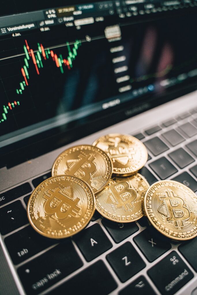 Notebook képernyőjén gyertya chart, billentyűzeten arany Bitcoin érmék; illusztráció Pine Script fejlesztéshez
